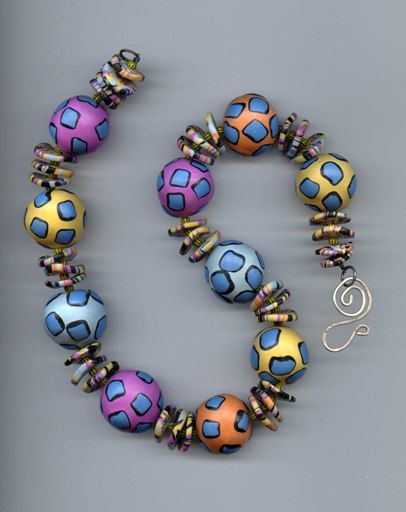 a multicolored beaded necklace with metal clasps on a gray background,