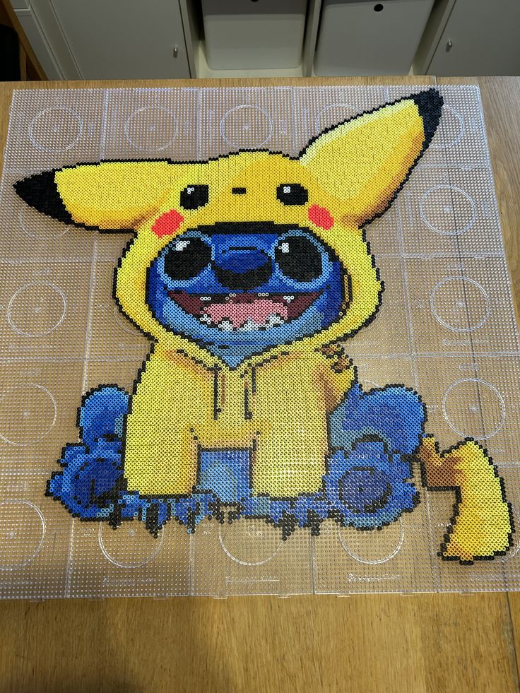 an image of a pikachu made out of plastic beads on a table top