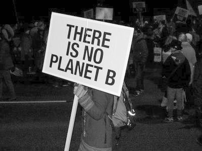 there is no planet b sign in front of a crowd at an occupy protest rally