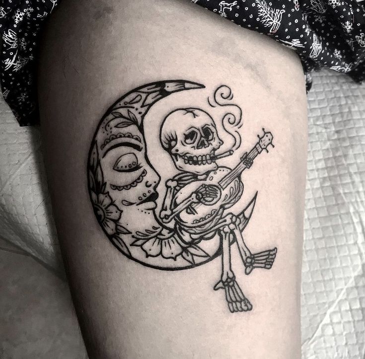 a black and white photo of a skeleton playing the guitar on the thigh with a full moon behind it