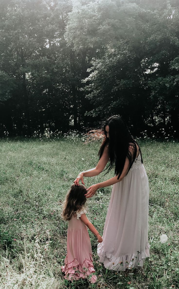 a mother and daughter playing in the grass