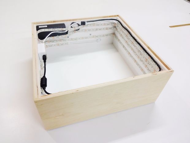 an open box with some wires in it on a white table next to a pair of scissors