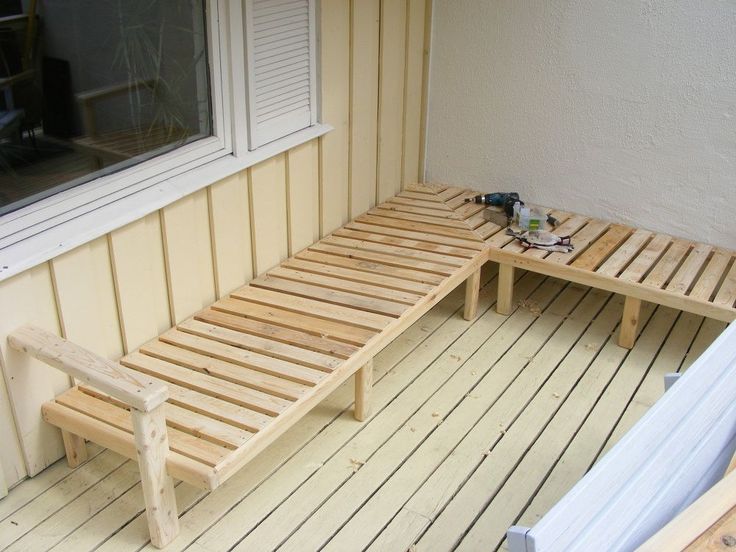 a wooden bench sitting on top of a hard wood floor next to a white wall