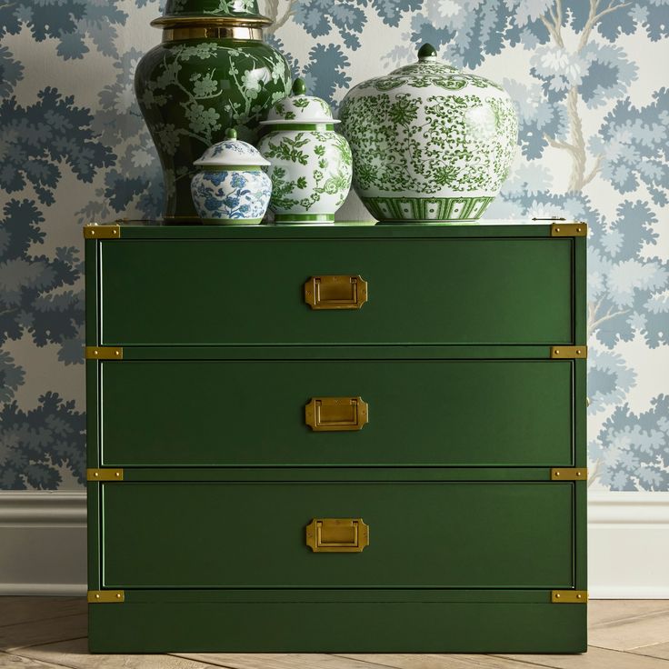 a green dresser with two vases on top and another one sitting on the other side