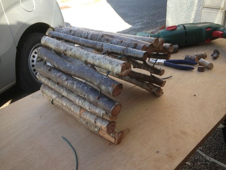 several pieces of wood sitting on top of a wooden table next to a wrench