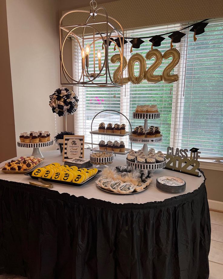 a table topped with lots of desserts and cupcakes