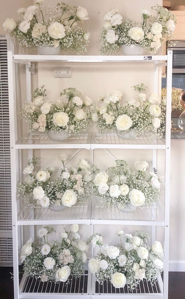 the shelves are filled with white flowers and baby's breath