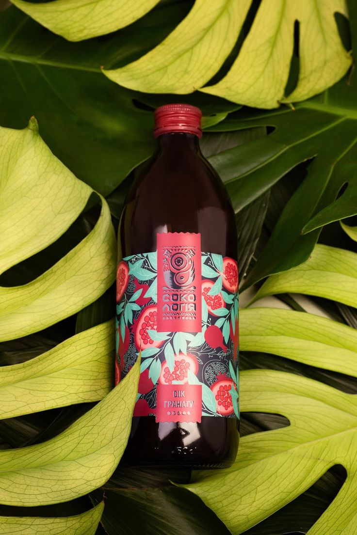 a bottle of liquid sitting on top of green leaves