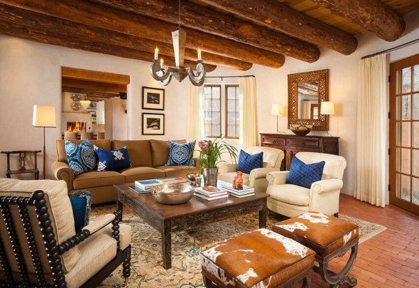 a living room with couches, chairs and tables in front of wooden beams on the ceiling