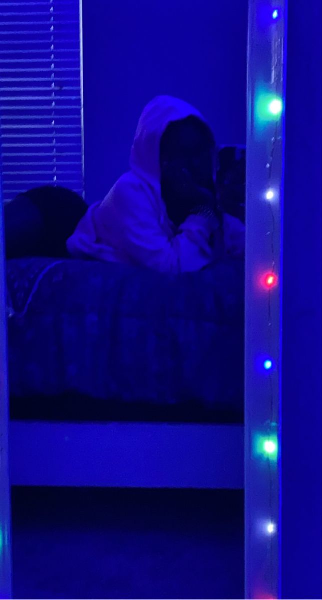 a person laying on a bed in a room with blue lights