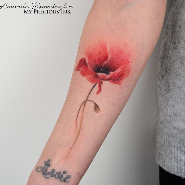 a red flower tattoo on the left arm and wrist, with an arrow in the middle