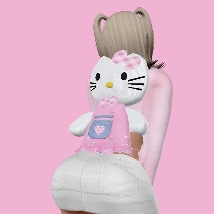 a hello kitty doll sitting on top of a white chair next to a pink wall