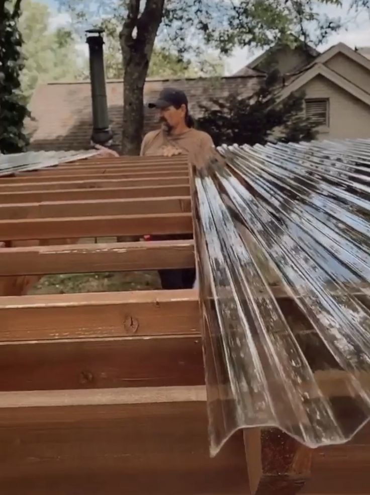 a man standing on top of a wooden roof