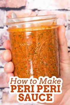 a hand holding a jar of homemade peri peri sauce with the words how to make peri peri sauce