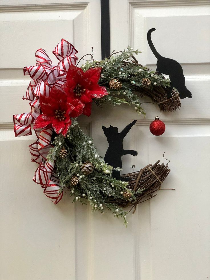 a wreath with a cat and christmas decorations on it