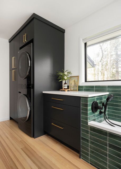 a washer and dryer in a room with wood flooring on the side