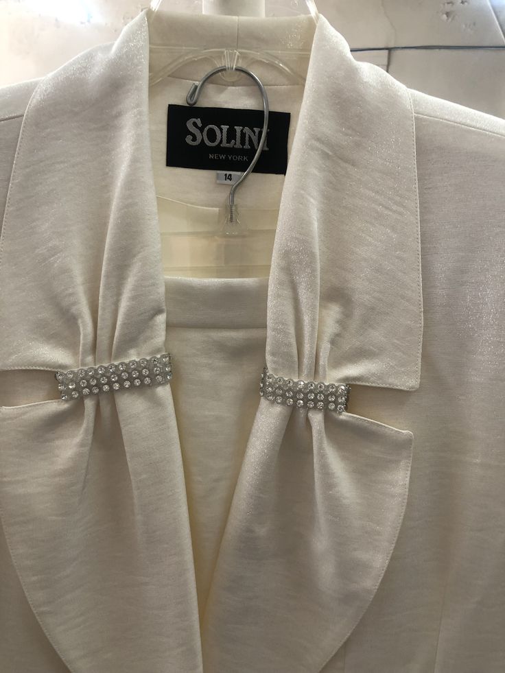 "1980's evening suit.   Cream colored two piece jacket and skirt.  Rhinestone embellishment at lapeland pockets with decorative button at jacket closure and shoulder pads.  Left leg slit in front.  Skirt has zipper in the back with elastic. Banded waist in the front.  Very \"Joan Collins\" Dynasty feel. Jacket chest:  44\" Sleeve 24\" Jacket length from neck to hem 30\" skirt side slit on left front 15\" waist to hem length 32\"" Joan Collins Dynasty, Long Suit Jacket, Evening Suit, Color Combinations For Clothes, Stunning Prom Dresses, Summer Linen Dresses, Tie Neck Tops, Embroidery Designs Fashion, Skirt Long