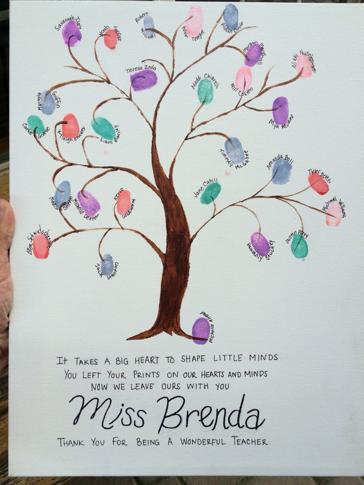 a child's hand holding up a card that has a tree with hearts on it