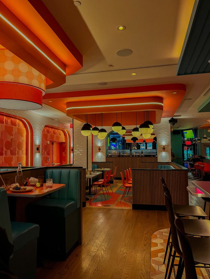 the interior of a brightly lit restaurant with wood floors and colorful lights on the ceiling