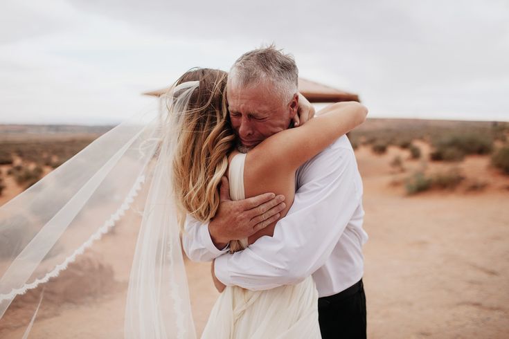 a man and woman embracing each other in the desert