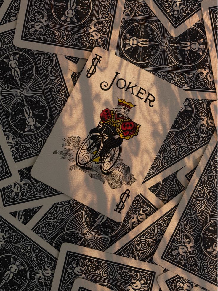 a pile of playing cards sitting on top of a table covered in black and white designs