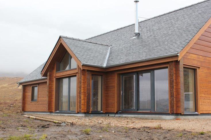 a large wooden house with windows and shingles