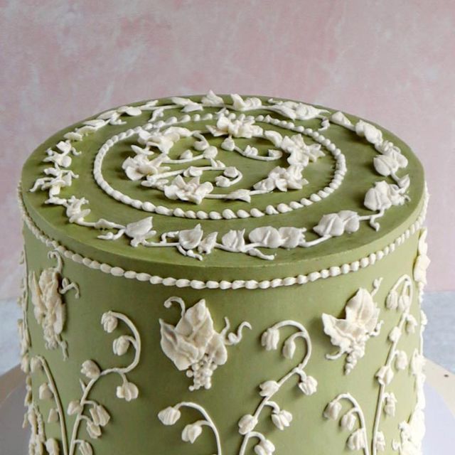 a green and white decorated cake sitting on top of a table