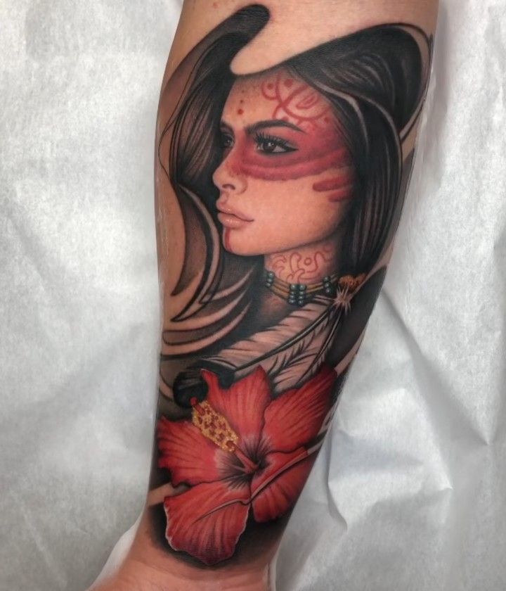 a woman's leg with tattoos and flowers on it