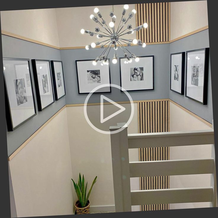 a chandelier hanging from the ceiling in a room with pictures on the wall