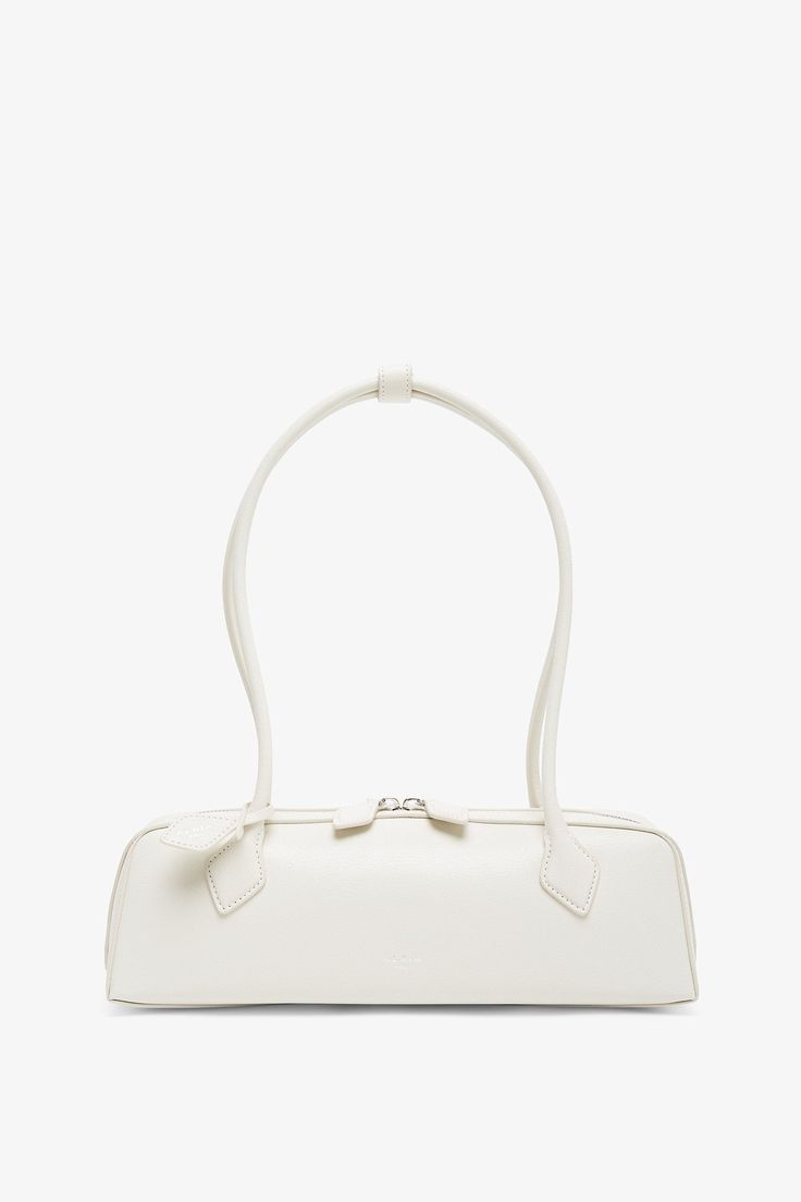 a white handbag is shown against a white background, with the handle on it