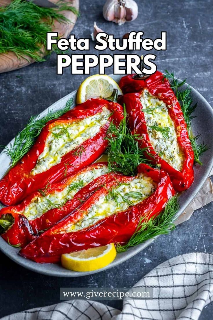 stuffed peppers in a pan with lemon wedges and dill garnish on the side