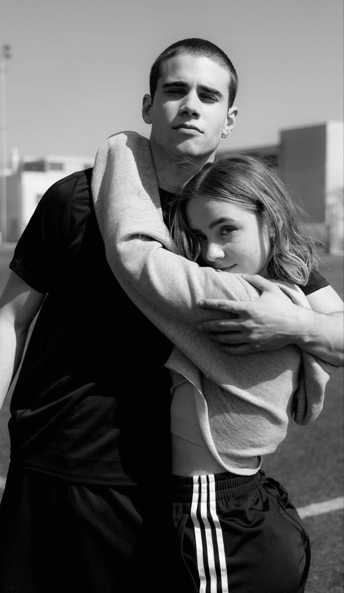 a man and woman hugging each other on the street