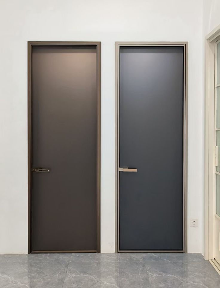 two doors are shown side by side in an empty room with no one around them