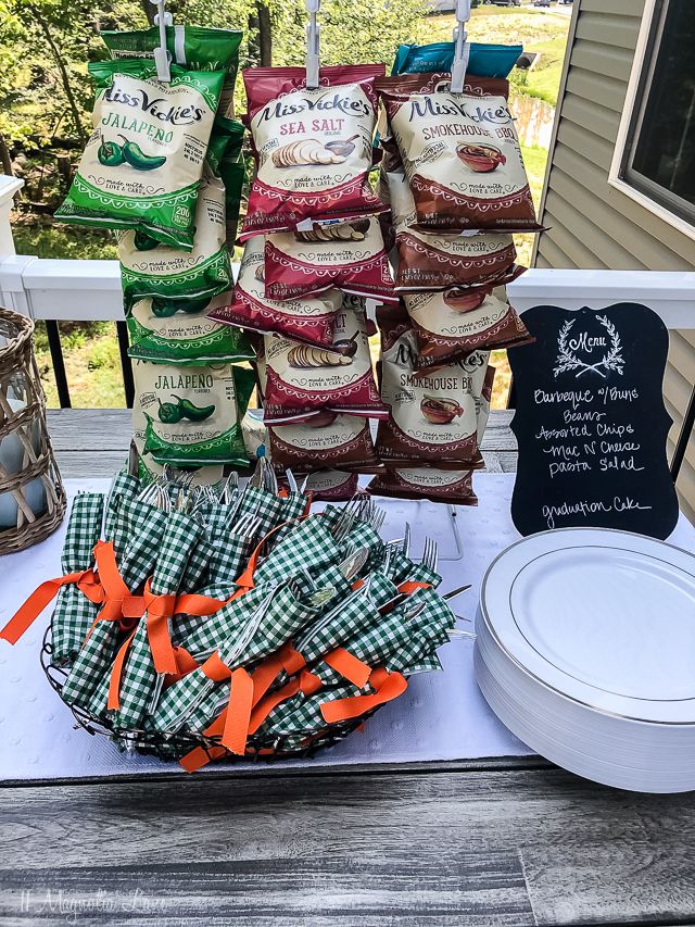 the table is set up with many bags of food on it and plates in front of them