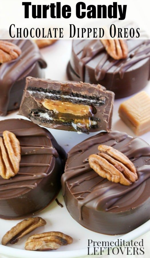 chocolate dipped oreos with pecans and caramel in the middle on a white plate