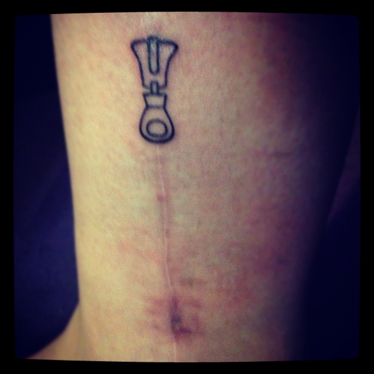 a small tattoo on the side of a woman's lower leg with a wrench