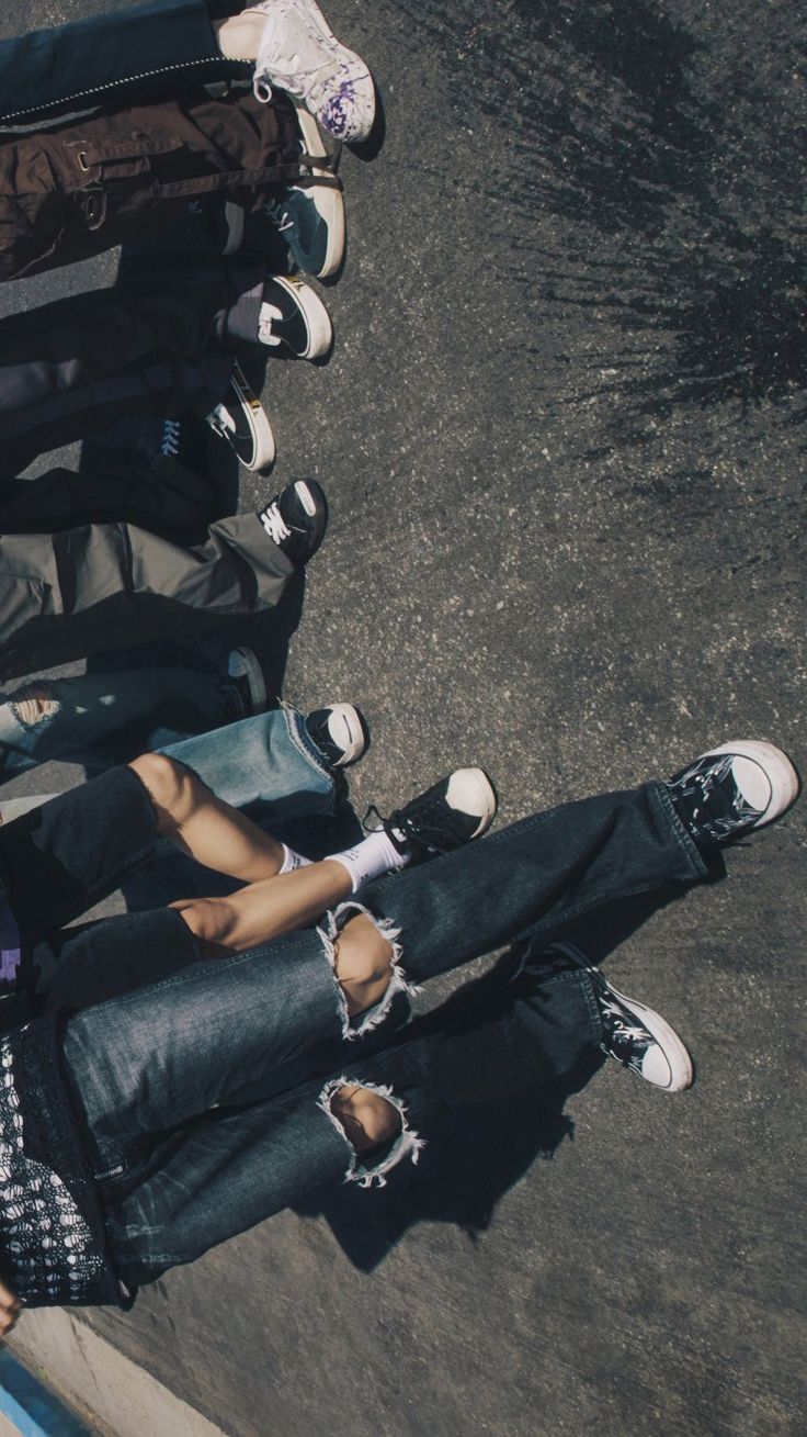 a group of young people standing next to each other on the side of a road