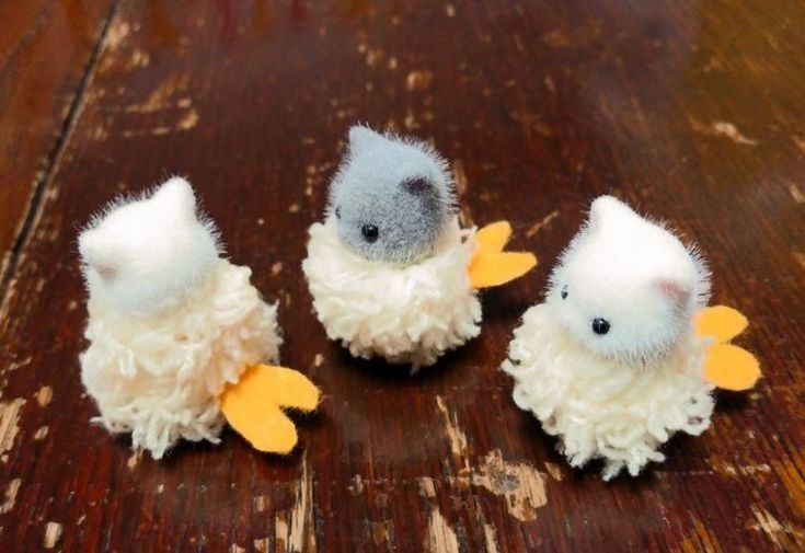 three small stuffed animals sitting on top of a wooden table