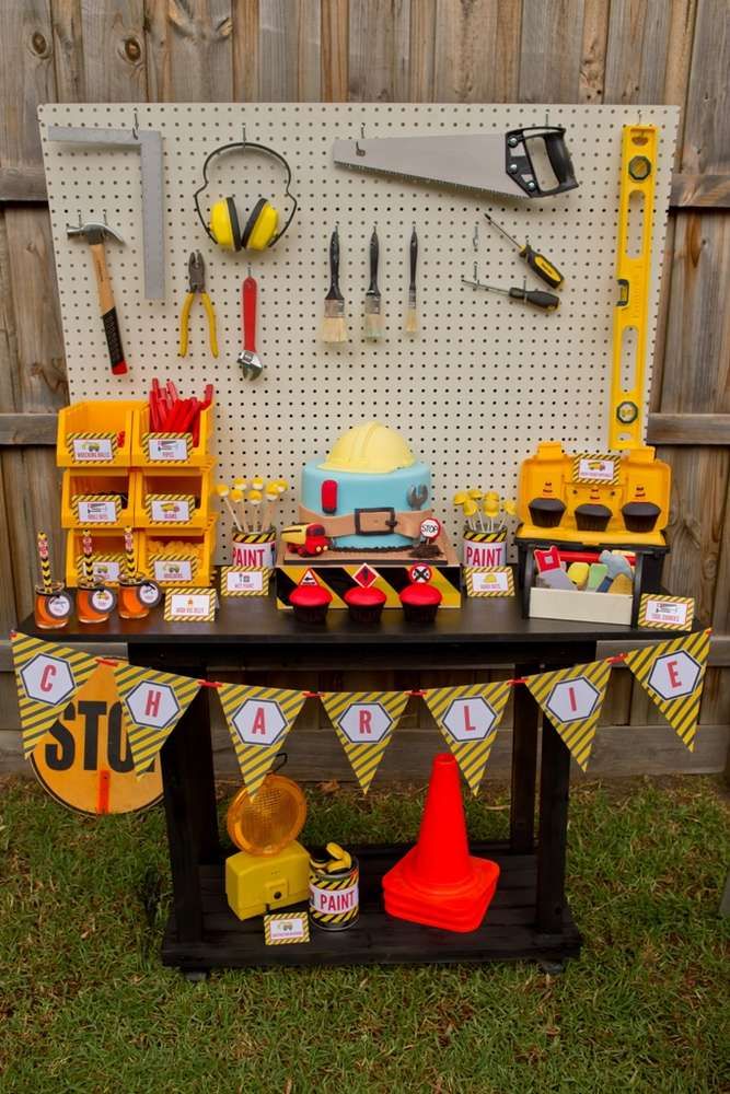 a table topped with lots of tools and construction themed signs on it's sides