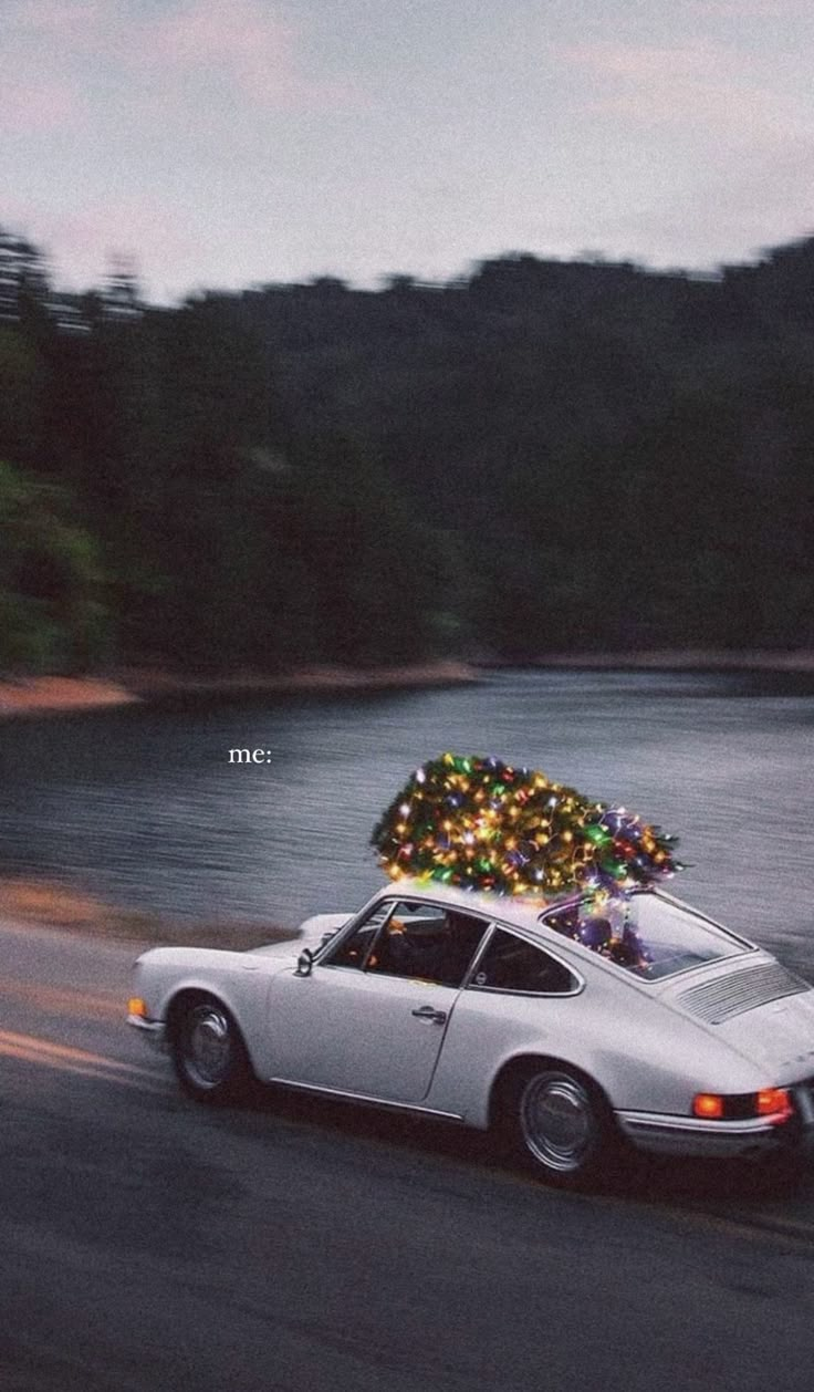 a white car driving down the road with a christmas tree on top