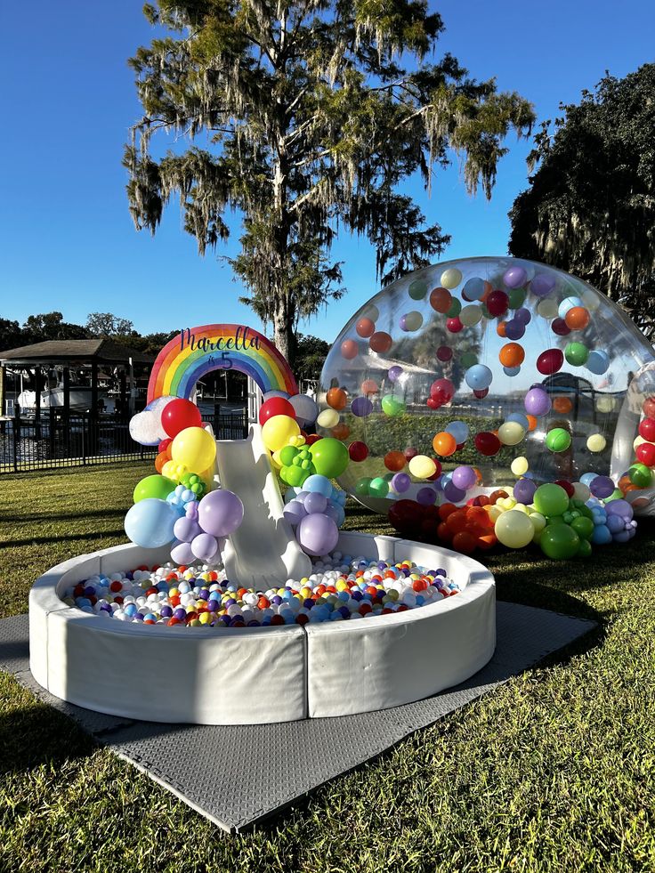 an inflatable ball pit with lots of balloons on the ground next to it