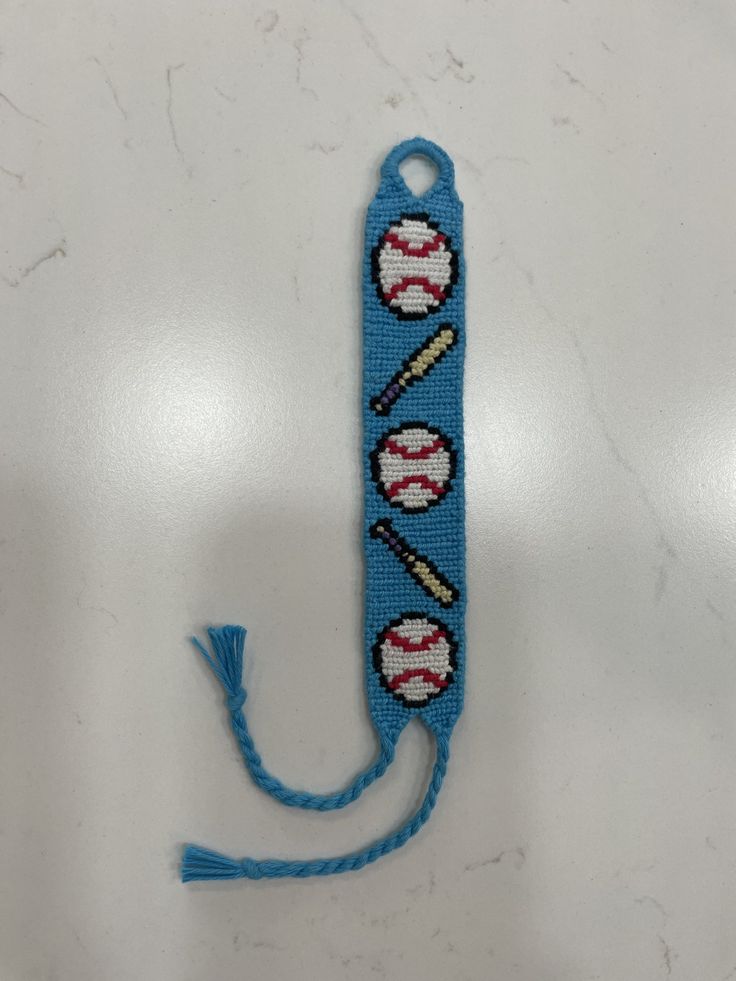 a blue beaded keychain with baseballs and bats on it