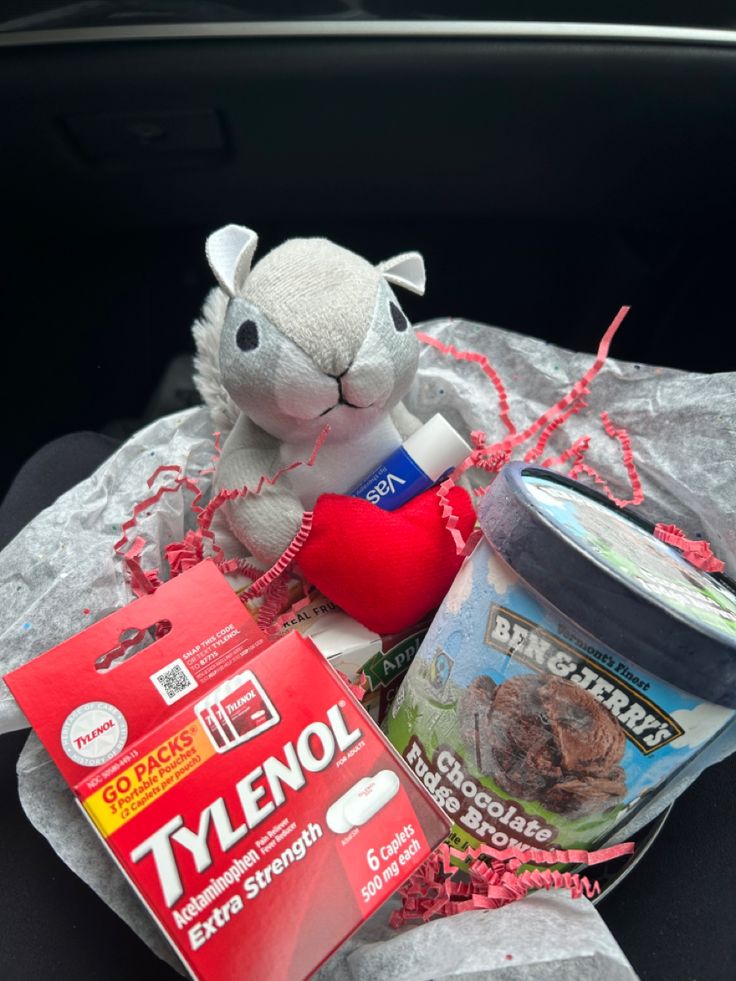 a stuffed animal sitting in the back seat of a car next to some food and other items