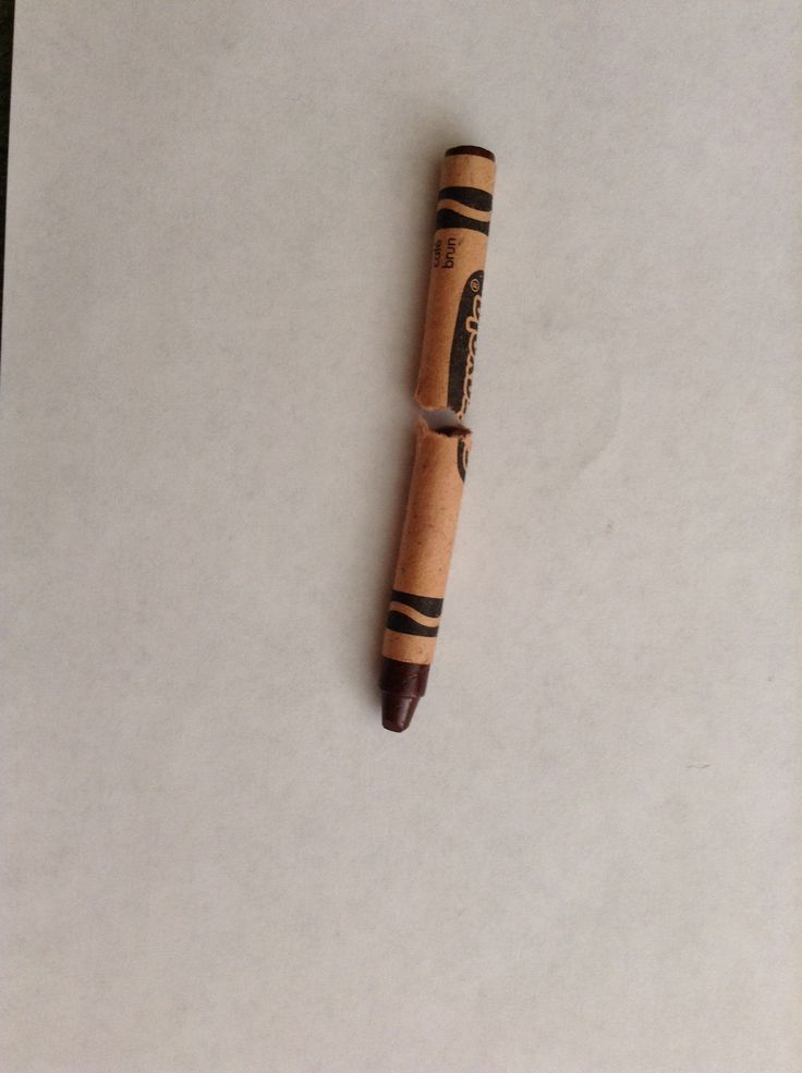 a wooden pen laying on top of a piece of paper with writing on the end