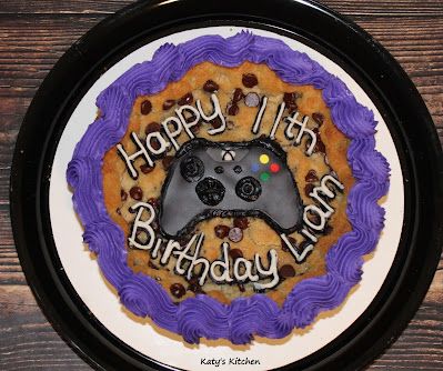 a birthday cake with a video game controller in the middle on a black and white plate