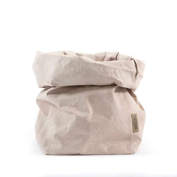 a white bag sitting on top of a white floor next to a black object in front of it