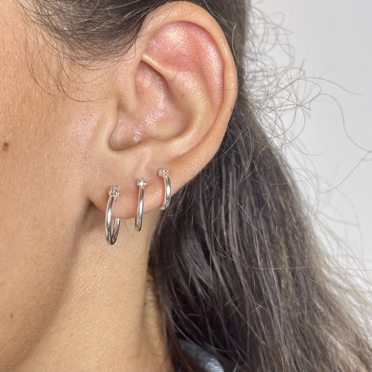 Handmade item Ships from a small business in Connecticut Materials: Silver Location: Cartilage, Earlobe Closure: Snap Top Style: Minimalist .925 sterling silver 1.5 x 10mm, 1.5 x 12mm or 1.5 x 14mm snap top hoop earrings.Hoops sold as a pair.To close, snap top down. Delicate style earring.Three sizes available to choose from, choose hoop size from drop down menu.*Please note due to hygiene reasons and for the safety of our customers and employees, pierced earrings are not returnable.Please make Hypoallergenic Silver Round Piercings, Classic Nickel-free Hoop Piercings, Classic Hypoallergenic Small Hoop Piercings, Classic White Gold Stackable Earrings, Classic White Gold Hoop Piercings, Nickel-free Classic Huggie Piercings, Silver Huggie Earrings With Prong Setting In Sterling Silver, Silver Sterling Huggie Earrings With Prong Setting, Silver Hypoallergenic Simple Piercings