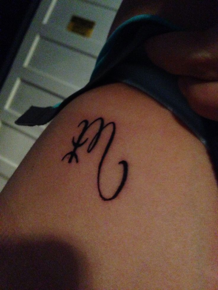 a woman with a tattoo on her arm that has the letter c in cursive writing