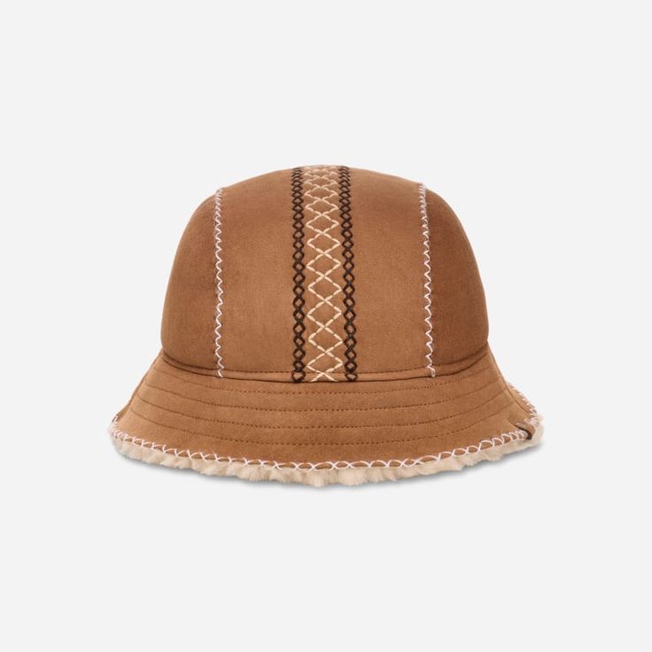 We're in stitches over how cute the Atherson Embroidered Hat is. Made with genuine sheepskin, this lovable bucket hat is primed for warmth. | Sheepskin bucket hat. Self - 100% Sheepskin. Lining - Unlined. Hand sewn and embroidered. UGG®braid embroidery detail. UGG® leather license plate label. Imported. | UGG® Women's Atherson Embroidered Hat Sheepskin Hats in Chestnut, Size L/XL Beige Hat With Embroidered Logo And Short Brim, Embroidered Brown Cap, Brown Flat Brim Hat With Embroidered Logo, Brown Flat Brim Bucket Hat For Winter, Braid Embroidery, Ugg Leather, Leather Hat, Area Rug Decor, Embroidered Hat