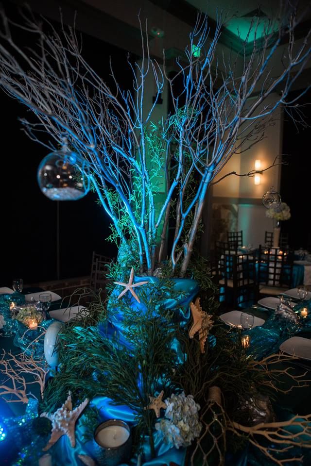 the centerpieces are decorated with blue lights and branches